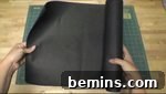 Person pulling out fabric onto a table, preparing the interfacing for the hat.