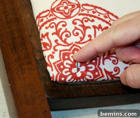 Pushing nail through fabric and padding