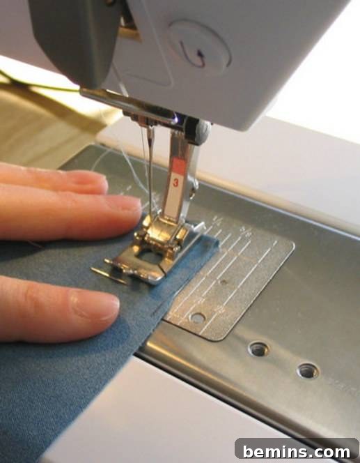 A person is stitching in a sewing machine.
