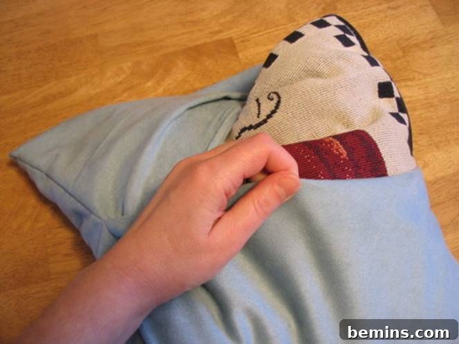 A pillow is covered with a pretty slipcover.