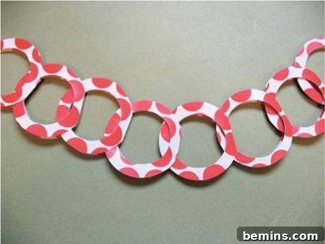 A paper design of pink hoops hanging on the wall, showing a no-glue ring garland alternative.