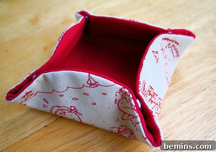 A handcrafted snap box made of red fabric, showcasing its snap closure for secure storage of small items.