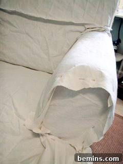 Your Easiest Slipcover Makeover 3 A person working on a DIY chair slipcover, showing fabric and sewing machine