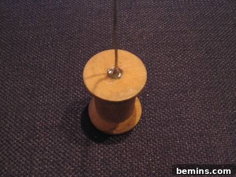 A wooden spool with wire inserted