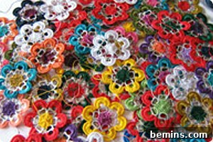 Crafting Blooms: Upcycled Pull Tab Flowers 3 Colorful craft flowers made from pull tabs sit in a pile.