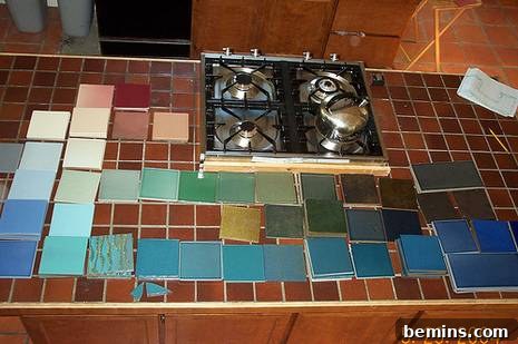 A collection of 6-inch tiles arranged by color. The old tile countertop is visible in the background.