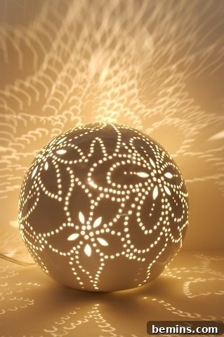 A porcelain ball lamp with intricate flower designs, emitting a soft, warm light.