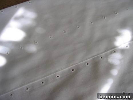 A white piece of material with lines of holes.