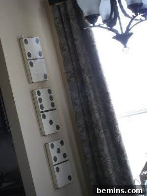 Three white vintage dominoes on a beige surface, showcasing the dot details.