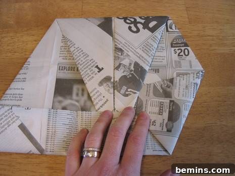 The completed origami baseball mitt, crafted from a section of newspaper.