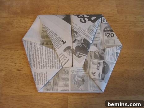 A close-up view of the newspaper origami mitt, showcasing the final folded form.