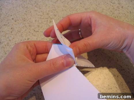 A person folding paper for origami craft.