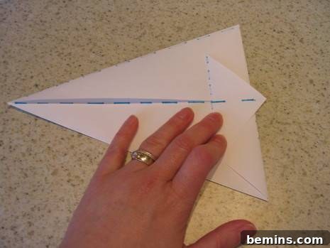 Origami Bunny: A Hopping Good Time 9 Folding the left point of the paper to the right edge, aligning with the straight edge.