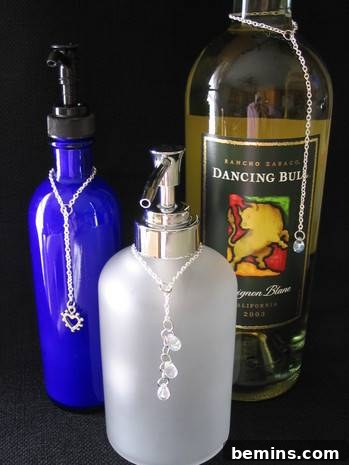 Three bottles of different colors and sizes wearing decorative bottle necklaces around their necks.