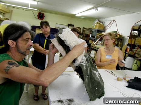 Pushing the specialized tufting needle upwards through the meticulously prepared upholstery layers