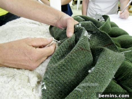 The tufting twine meticulously brought to the surface through the marked upholstery fabric for button attachment