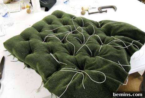 Master upholsterer Kim Buckminster swiftly and expertly securing buttons for perfect diamond tufting