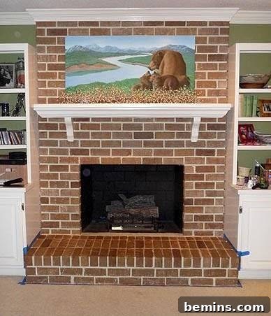 An empty fireplace with a landscape painting on top, showcasing the completed faux brick effect and the overall aesthetic transformation.