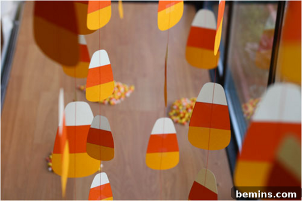 7 Fall Garlands to Craft for a Cozy Weekend 6 Playful candy corn garland crafted from fabric or felt, showcasing the classic white, orange, and yellow design.