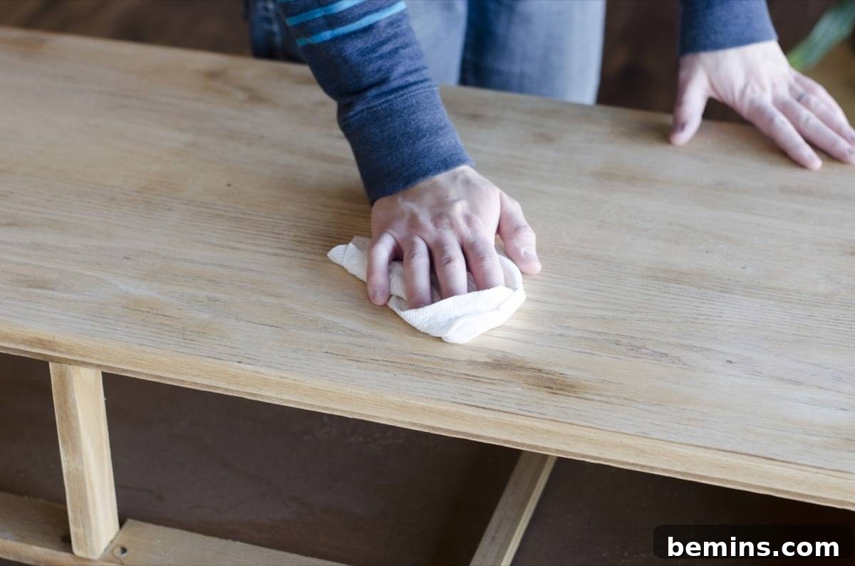 Image demonstrating the cleaning of the dresser. A damp rag is being used to remove dust and debris from the surface.