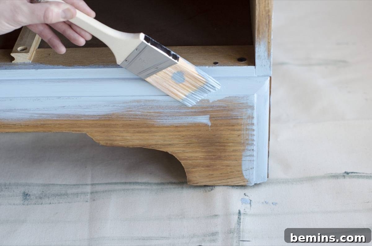 Image demonstrating the use of an angled brush for painting detailed areas of the dresser. The image highlights the importance of precision when painting intricate details.