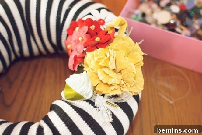 Ultimate DIY Holiday Wreath Ideas 13 A black and white ring with red and yellow cloth flowers on it sitting next to a pink box.