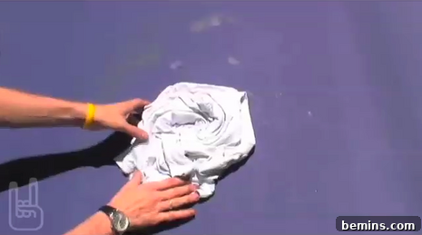Person balling up a white t-shirt so that it is bunched up.