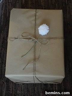 Gift box tied with tread and top up with white yarn pom pom.