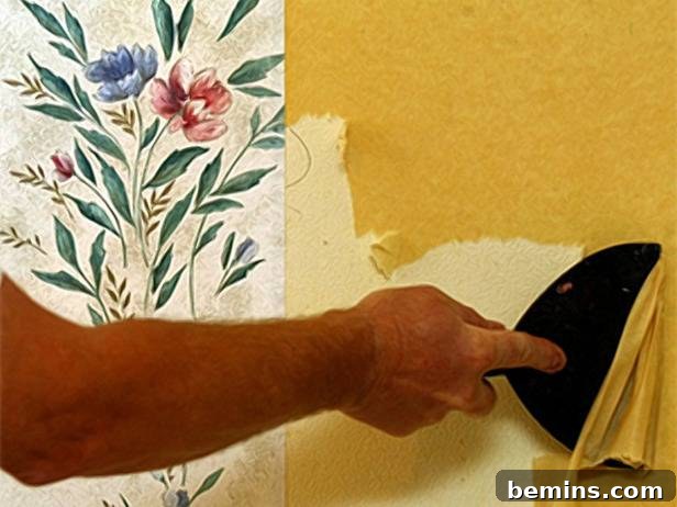 Removing old wallpaper with a scraper