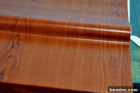 Measuring and cutting the wood grain contact paper.
