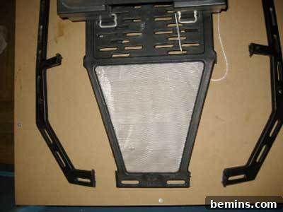 Black plastic form with white hexagonal piece next to two black handles.