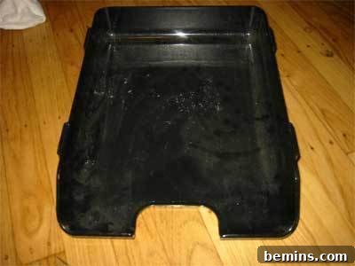 Black pan on a golden brown wood floor.