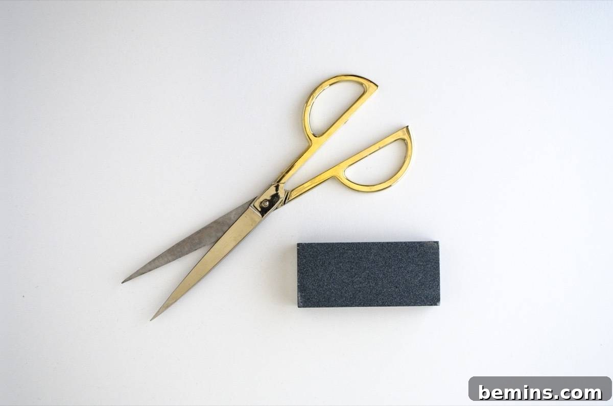 Sharpening scissors on a sharpening stone with proper angle.