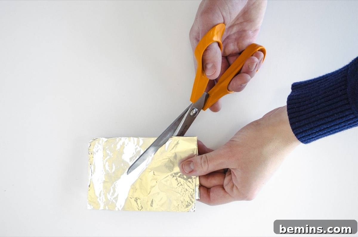 Sharpening scissors using multiple layers of aluminum foil.