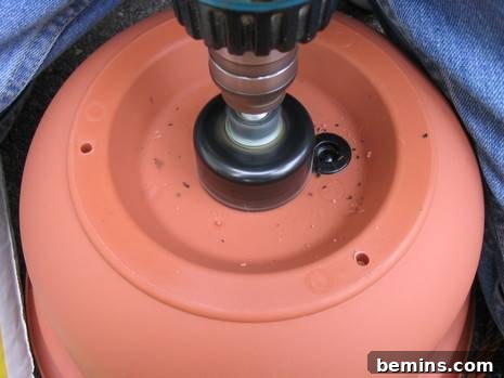 Making An Upside Down Tomato Planter: drill a hole in the bottom of the pot.