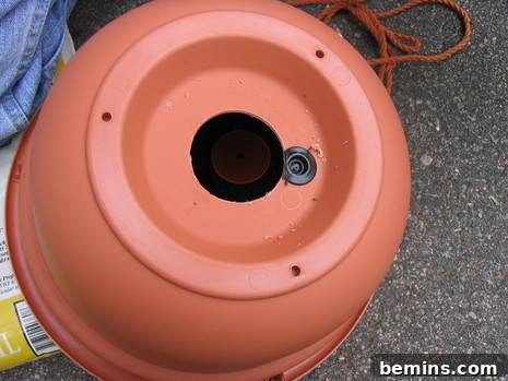 Plastic terra cotta pot bottom on top of asphalt outside.