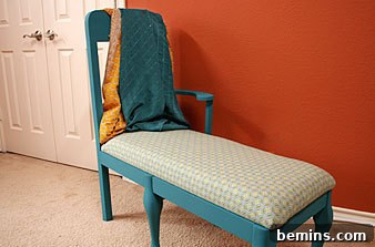 A blue bench in a room with red walls and white doors.