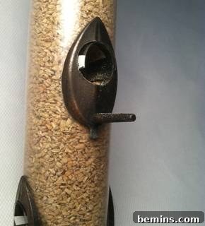 Affix edge with small amount of appropriate adhesive.  When dry, re-fill with seed and re-hang.