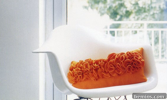 Orange pillow on the white chair.