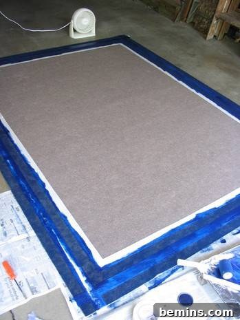 A close-up view of the blue paint applied to the rug, showcasing the defined lines created by the masking tape.