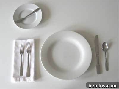 Silverware placed correctly: forks to the left of the plate, knife and spoon to the right, and a butter knife on the bread plate.