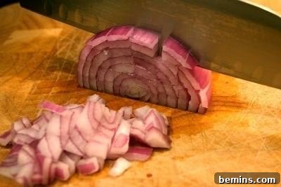 Person is chopping the onion with knife.