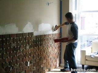 Brick by Brick: Creating a Loft-Style Interior Wall 5 A man installing the thin brick veneer on the wall