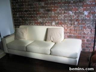 Brick by Brick: Creating a Loft-Style Interior Wall 6 A white sofa sitting in a room with the completed brick wall