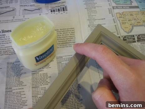 Vaseline Wood Distressing: A Simple DIY Guide 4 Woman spreading petroleum jelly on a wood picture frame.