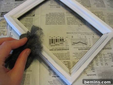 Vaseline Wood Distressing: A Simple DIY Guide 6 A hand cleaning a wooden frame with a material