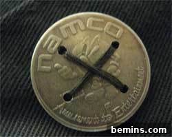 Gold button sewn to denim, showcasing the finished DIY coin button project.