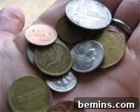 Person holding a handful of diverse coins, showcasing the variety of options for DIY coin buttons.