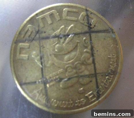 Close-up of a coin with marked drilling points, showing the precision required for creating functional buttons.