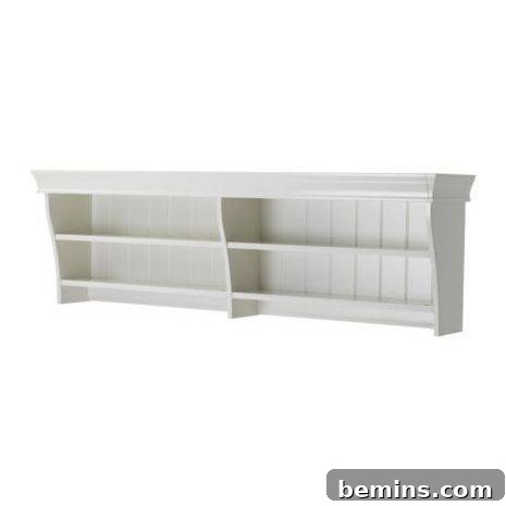 White shelf with two shelves and wide top mounted on a wall.